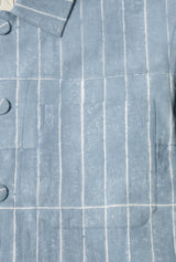 Close-up of a blue shirt with white pinstripes and button details.