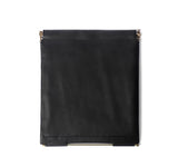 Front view of the black Muse Clutch bag showing its smooth leather texture and structured flap closure with subtle branding.