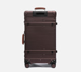 Rear view of a premium brown trunk luggage. This hard shell suitcase features a vintage design and spinner wheels