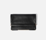 Nappa Dori Muse fold-over clutch in black pebbled leather with gold hinge hardware.