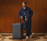 Wingman brown luxury luggage trunk. This hardshell spinner suitcase is a premium travel luggage piece for international.